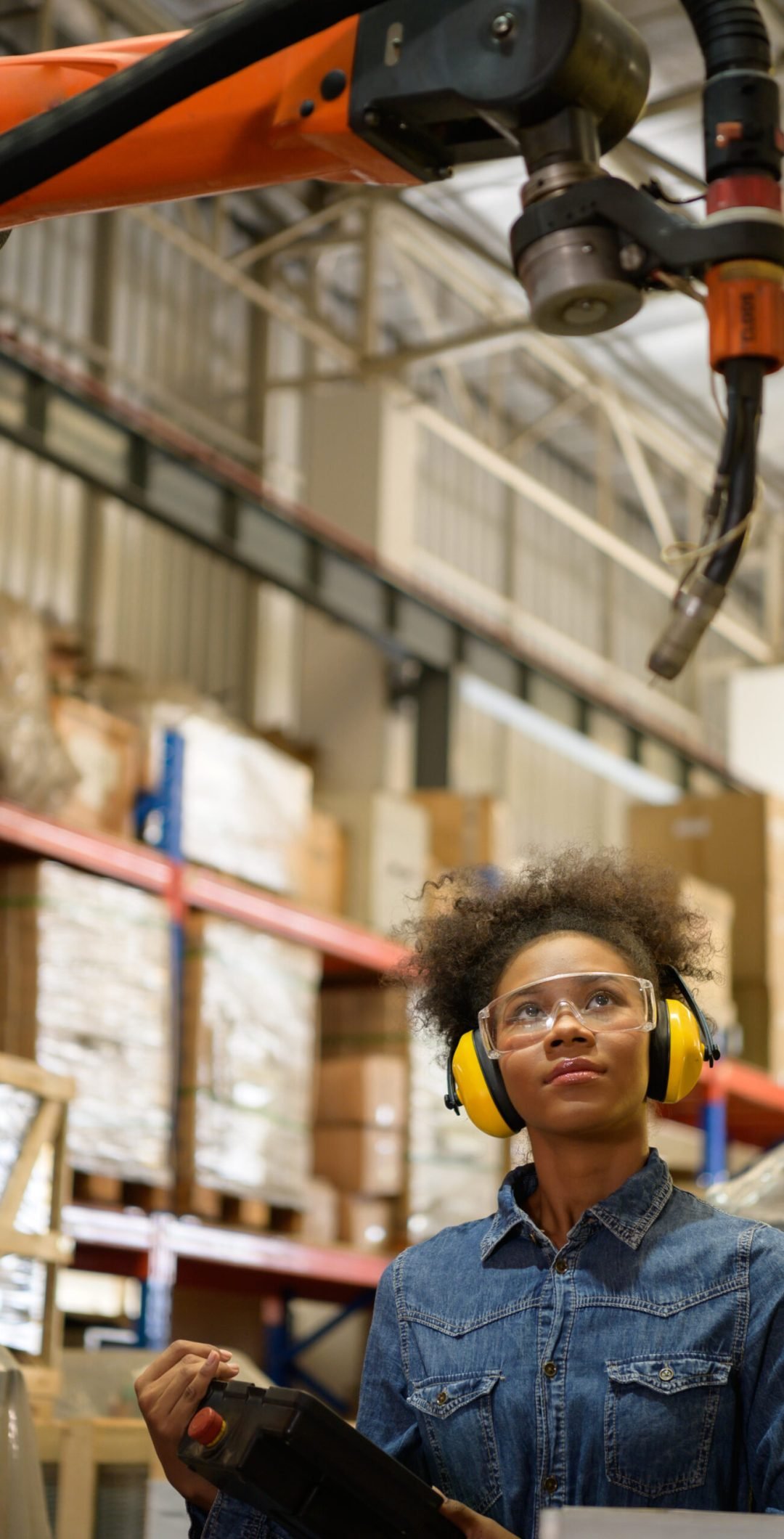 A young female worker is controlling a mechanical robot. to sort out the items that come into the warehouse to wait for the next shipment.